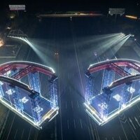 China: rail engineers swing two halves of arch bridge over road ...